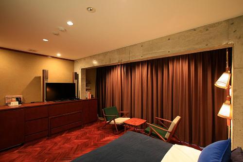 东京D工作室酒店的酒店客房,配有床和电视