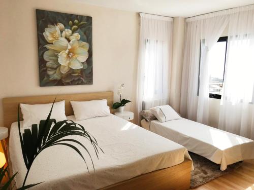 阿德耶维帕莱索公寓 的一间卧室设有两张床,墙上挂着一幅画