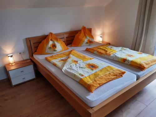 温蒂加斯顿Ferienwohnung Brandstätter的两张带橙色和黄色枕头的床