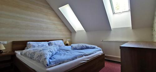 迪马诺卡多林纳Apartment No.28 Jasná的一间卧室配有一张带蓝色床单的床和一扇窗户。