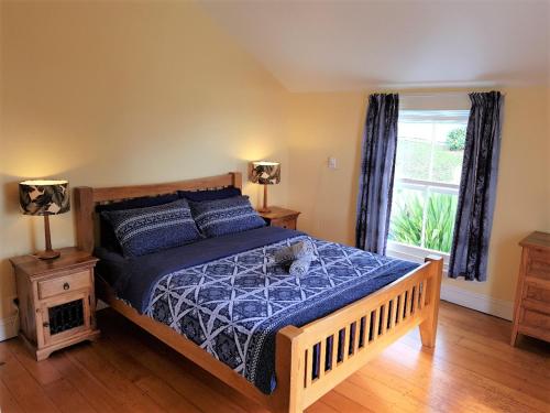 阿希帕拉无尽夏日小屋旅舍的一间卧室配有一张带蓝色棉被的床和窗户。