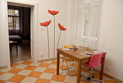 布拉格Just BE that´s enough!!的一间用餐室,配有一张桌子和墙上的红色鲜花