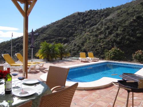 阿里纳斯Belvilla by OYO Casa Martijo的一个带桌椅的游泳池和一个山