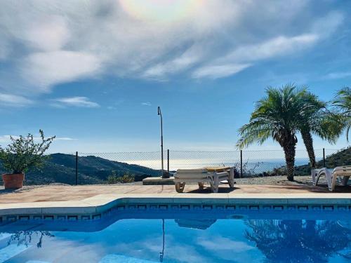 阿里纳斯Belvilla by OYO Casa Martijo的一个带野餐桌和棕榈树的游泳池