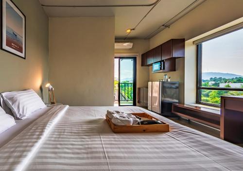 合艾Bhava Residence的一间卧室设有一张大床和大窗户