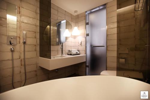 釜山Londoner Hotel Gwangan的一间带卫生间、水槽和镜子的浴室