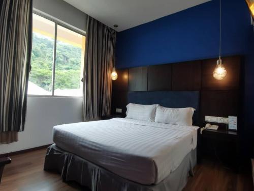 山打根2 Inn 1 Boutique Hotel & Spa的一间卧室设有一张蓝色墙壁的大床