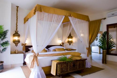 布韦朱巴拉扎桑给巴尔Spa度假村的一间卧室配有带窗帘的天蓬床