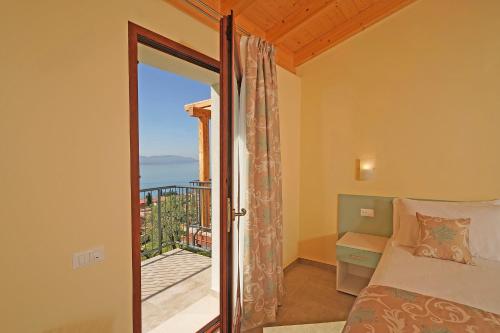 加尔尼亚诺Residence Dany appartamenti con cucina vista lago piscina e parcheggio的一间卧室配有一张床,享有海景