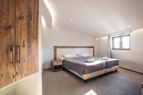 卡沃斯Island Kavos的一间卧室配有一张床和一个木制橱柜