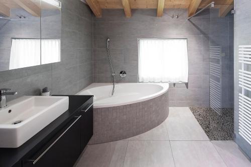 格林德尔瓦尔德雷娜塔公寓的浴室配有白色浴缸和水槽