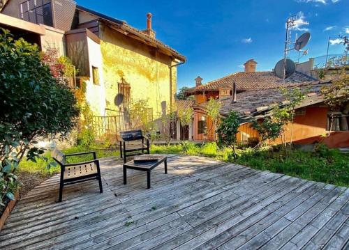 瓜热讷Il Giardino sul Tetto B&B的两把长椅坐在房子前面的木甲板上