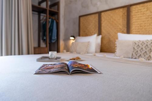 普拉索尼西Oasis Hotel Prasonisi的书,坐在床上,带托盘