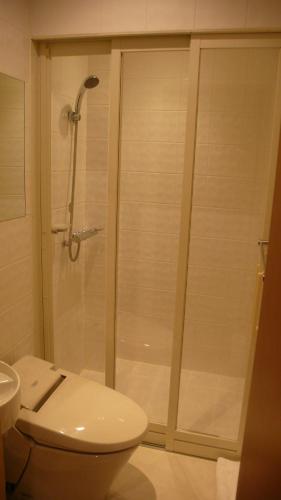 白马村双黑酒店的带淋浴、卫生间和盥洗盆的浴室