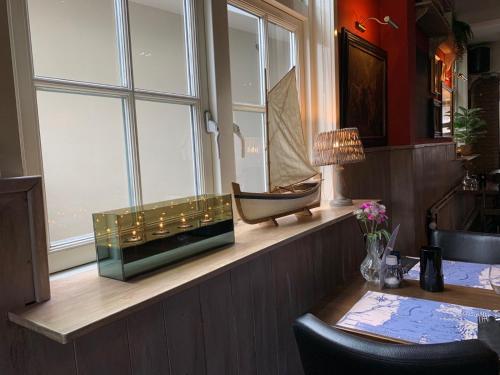 洛斯德雷赫特喜力咖啡餐厅酒店的一间设有窗户、桌子和桌子的房间
