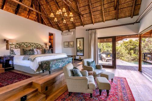 帕特森Lalibela Game Reserve - Kichaka Lodge的一间卧室配有一张床和椅子,还设有一个庭院