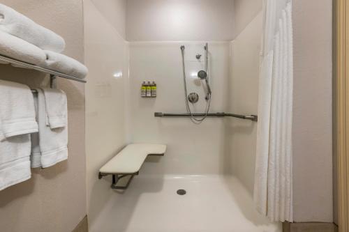 退休小镇村庄智选假日酒店的白色的浴室设有淋浴和浴缸。