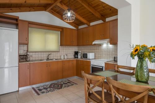KávallosBluefairy Villas的厨房配有木制橱柜和花瓶桌子。