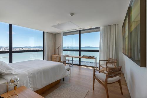 弗洛里亚诺波利斯LK Design Hotel Florianópolis的一间卧室配有一张床,享有海景