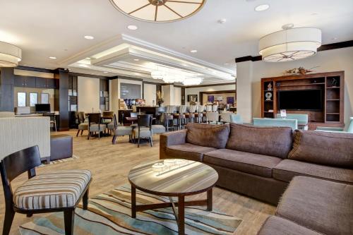 滑铁卢Holiday Inn Express Hotel & Suites Waterloo - St. Jacobs Area, an IHG Hotel的客厅配有沙发和桌椅