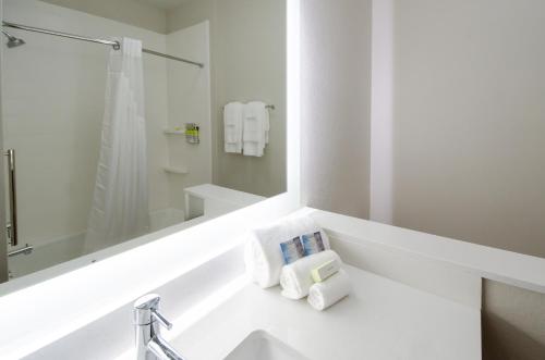 泰勒Holiday Inn Express & Suites Taylor, an IHG Hotel的浴室配有带镜子的盥洗盆和毛巾