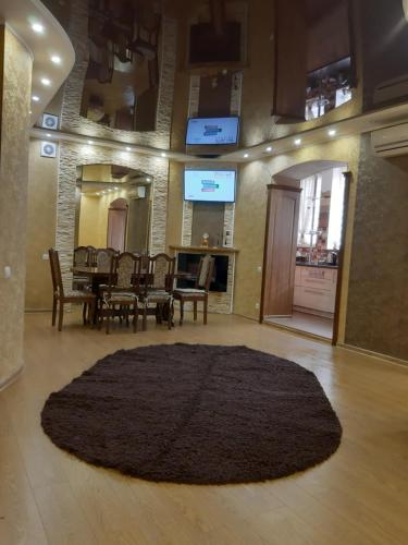 尼古拉耶夫Lux apartment City Center的一张大地毯,房间配有桌椅