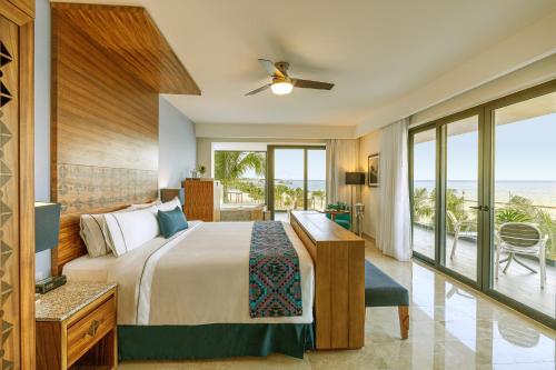莫雷洛斯港Sensira Resort & Spa Riviera Maya All Inclusive的一间卧室配有一张床,享有海景
