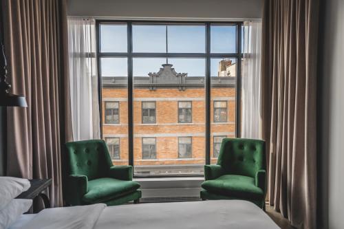 三河城Hotel Oui GO!的酒店客房设有两把绿色椅子和窗户。