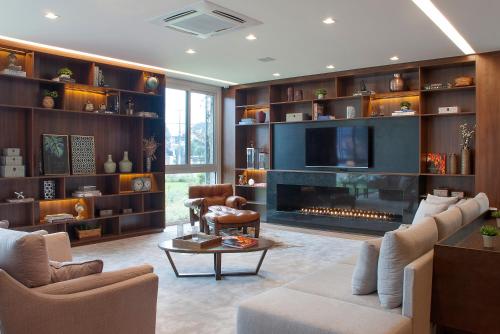 格拉玛多Exclusive Gramado Hotel & Spa by Gramado Parks的客厅设有壁炉和电视。