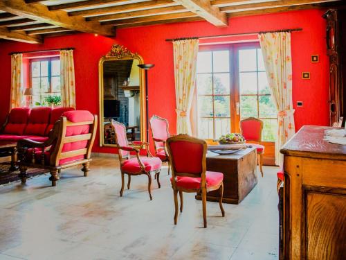 比埃夫勒Appealing villa in Bi vre with garden的客厅设有红色的墙壁、椅子和桌子