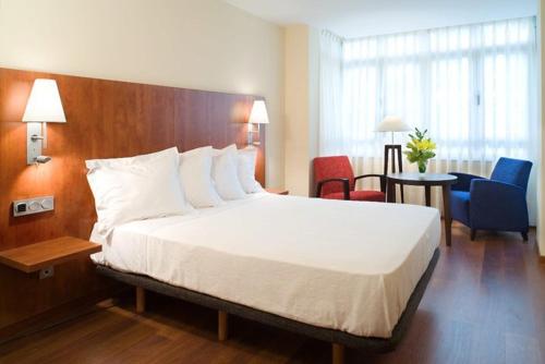 希洪阿伦纳酒店的酒店客房带一张大床和椅子