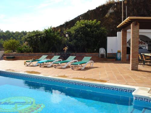 内尔哈Belvilla by OYO Casa Mirador的一组躺椅和一个游泳池