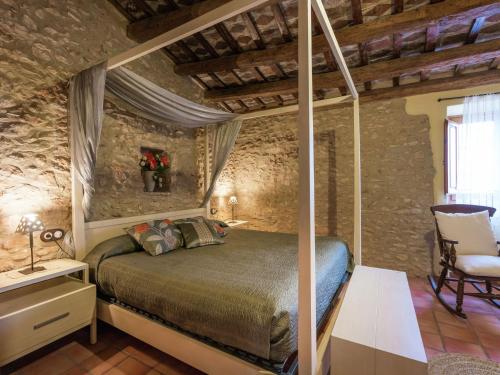 Bisbal del PenedèsLuxurious Mansion in Catalonia with Sauna的石头房中一间带天蓬床的卧室