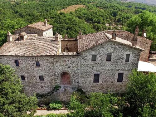 温贝尔蒂德Valley View Farmhouse in Umbertide with Pool and BBQ的一座古老的石头建筑,山上有一扇门