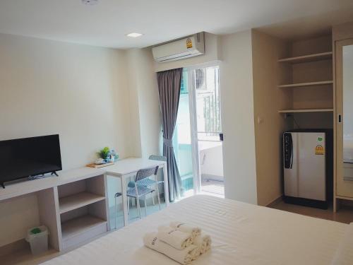 曼谷 普里玛住宿酒店 - SHA Certificate的小客房配有一张带书桌的床铺和一台冰箱