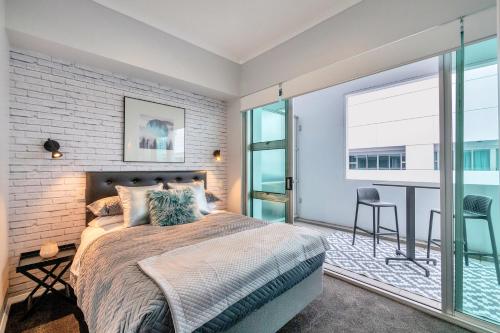 奥克兰Princes Wharf Boutique Apartments的一间卧室设有一张床和一个大窗户