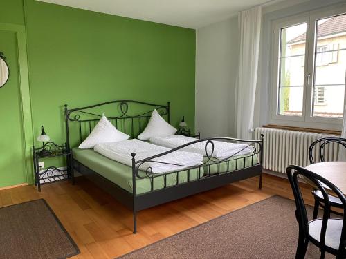 朗根塔尔BnB Hopfengrün Langenthal的绿色卧室配有床和桌子