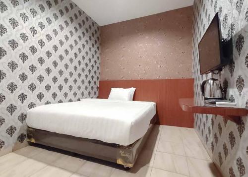 Pulauberayan DadapRedDoorz Plus @ Jalan Letda Sujono Medan 2的卧室配有白色的床和墙壁