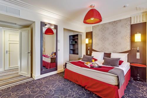 顿河畔罗斯托夫顿河畔罗斯托夫中心美居酒店的配有一张大床和镜子的酒店客房