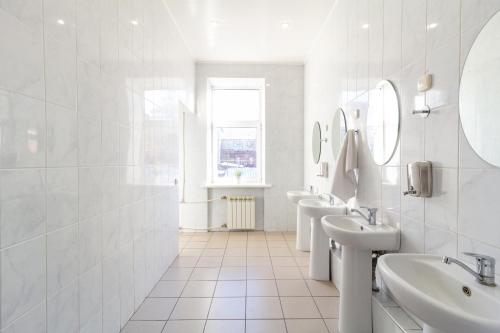 萨马拉沃尔纳酒店的白色的浴室设有3个水槽和镜子