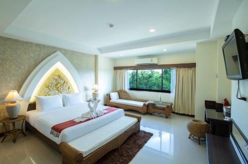 Nang Rong武里南帕侬荣蒲里酒店的酒店客房,配有床和电视