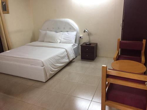 Bilād Manaḩ努尔麦吉露营酒店的卧室配有白色的床和木桌