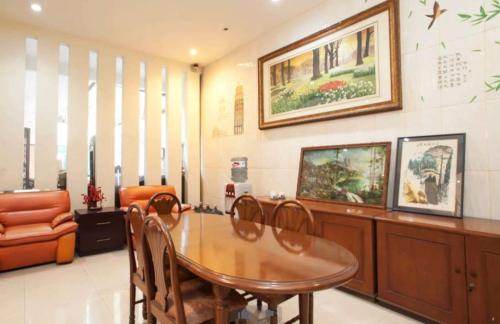 泗水Soerabaja Place Guest House的一间带木桌和椅子的用餐室