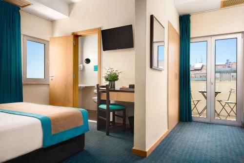 里斯本DAH酒店 - 多姆阿丰索亨利克斯的酒店客房设有一张床、一张书桌和窗户。
