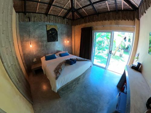 拉迈亚洲秘密度假村的一间卧室设有一张床和一个大窗户