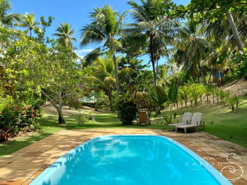 因巴塞卡匹图酒店的棕榈树庭院中的蓝色游泳池