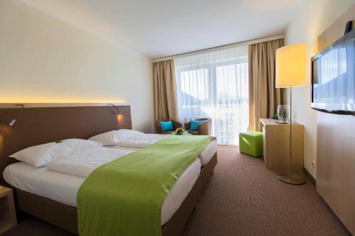 阿尼夫动量酒店的酒店客房设有一张大床和一台电视。