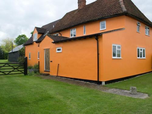 BirchWoodview B&B Colchester的一座带绿色庭院的大型橙色房屋