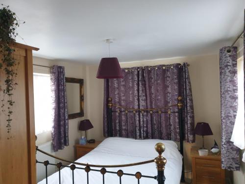 诺里奇夏日住宿加早餐旅馆的一间卧室配有一张紫色窗帘的床