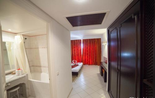 莫纳斯提尔自由度假酒店的一间带水槽和红色窗帘的浴室